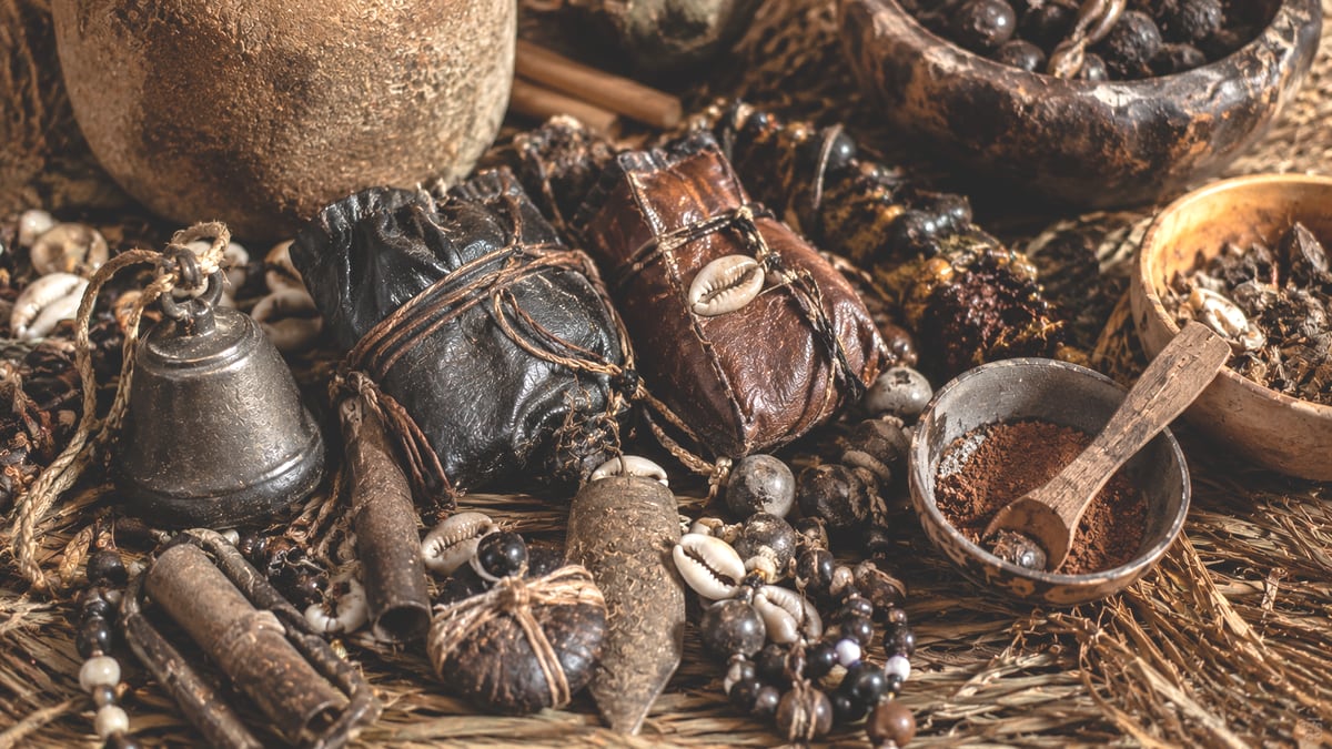 Petites bourses de cuir et cauris posés sur une natte tressée